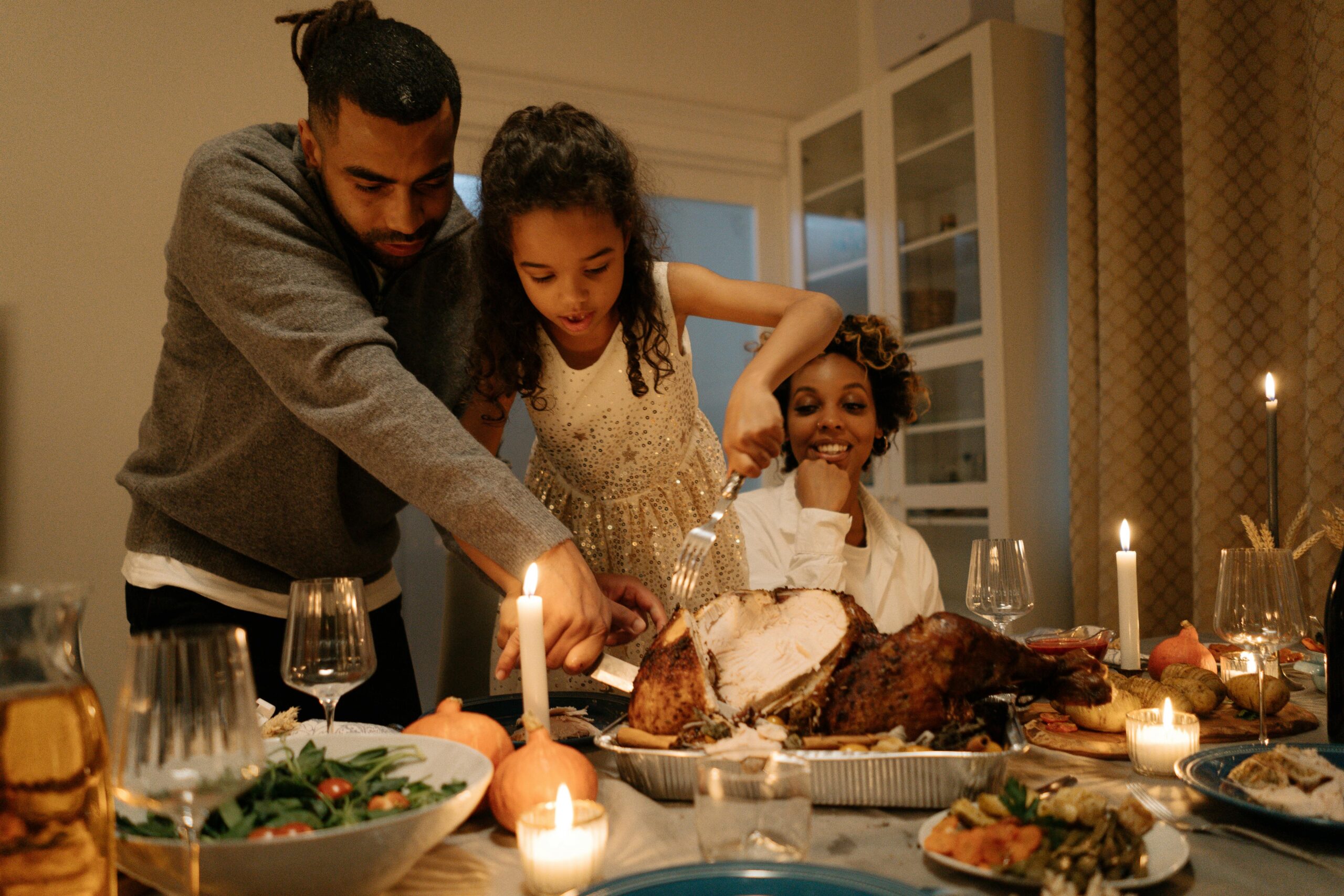A joyful family gathering around a table to celebrate Thanksgiving with a delicious turkey meal.