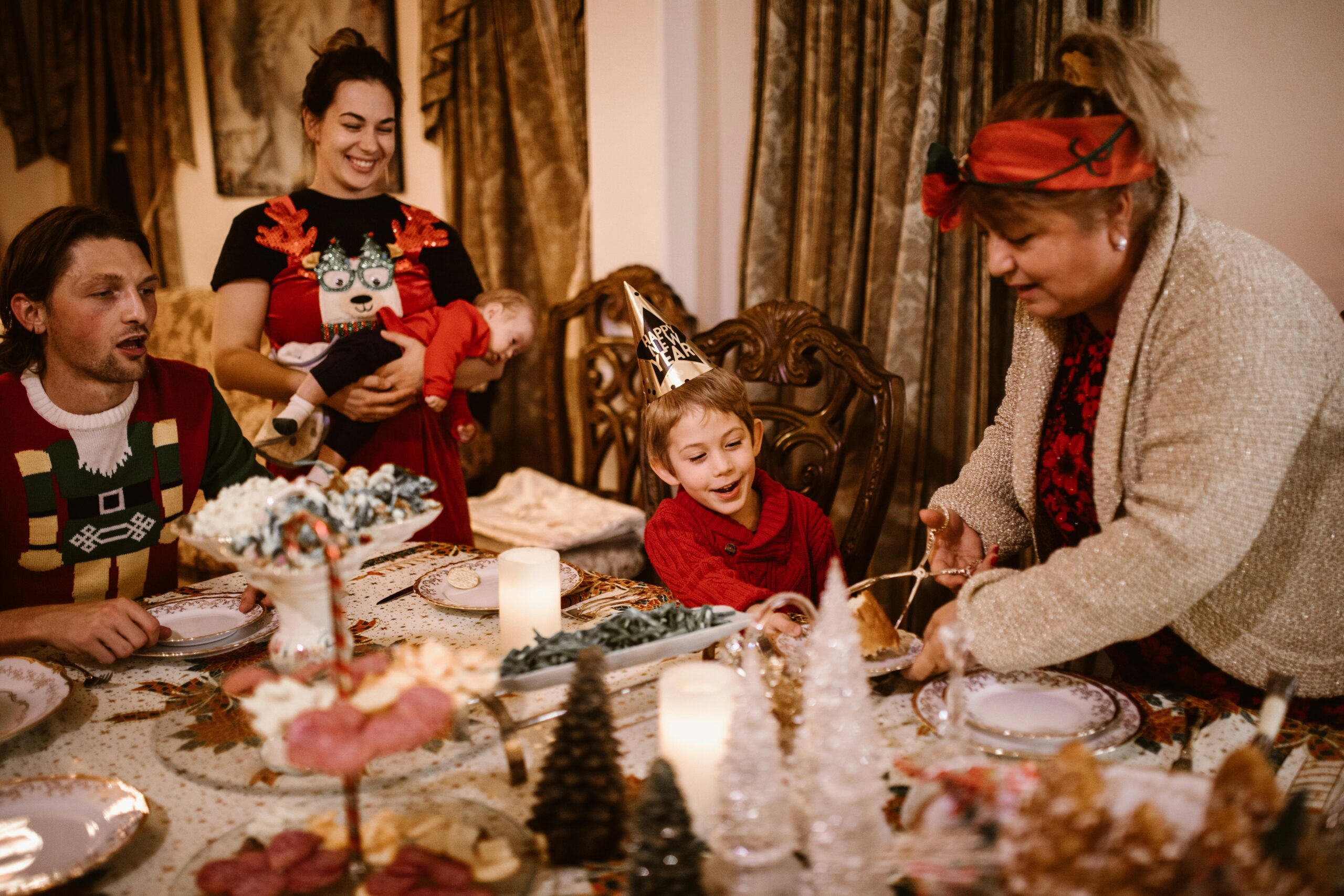 A joyful family gathering around a Christmas dinner table, celebrating together indoors.