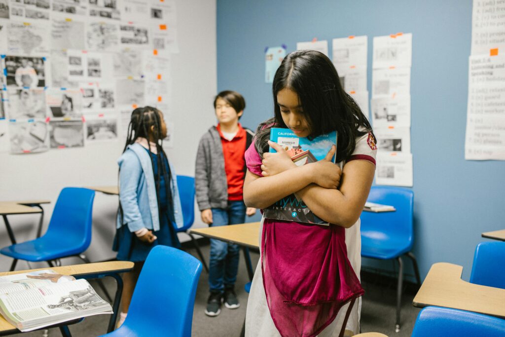 Ethnically diverse children in a classroom, highlighting social dynamics.